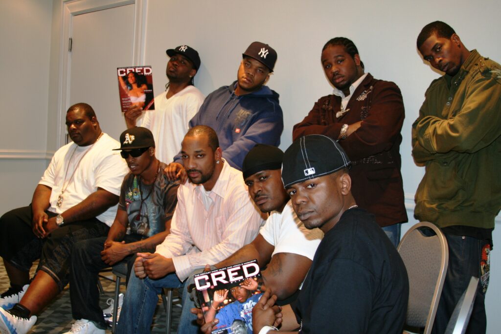 D-Block / The LOX with interviewer LD Williams and musician and producer Elijah LX Harvey, seated and standing in a hotel room, holding copies of CRED Magazine