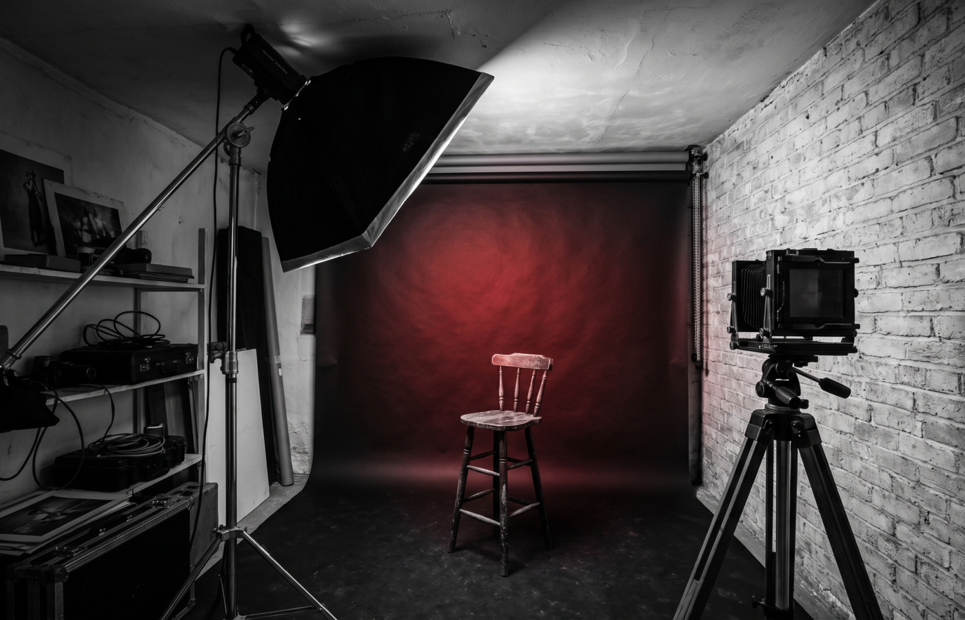 A cramped small photo studio with a low ceiling, a softbox nearly touching it, and a backdrop only a few feet behind an empty stool